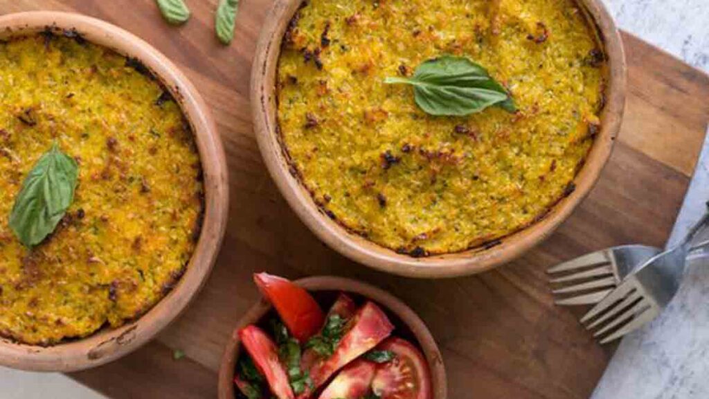 dos platos de pastel de choclo con tomate con cebolla